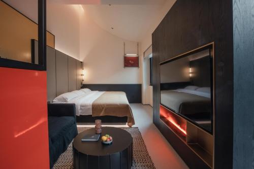 a hotel room with a bedroom with a bed and a table at PingYao Chengfu Jinyuan Hotel in Pingyao