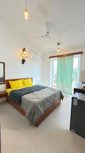 a bedroom with a large bed with yellow pillows at Triyaah Pool View Studios Arpora, Goa in Arpora
