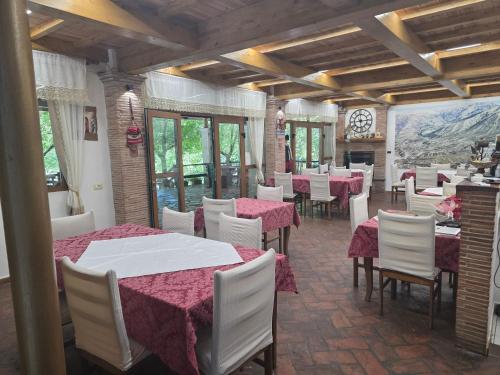 a dining room with tables and white chairs at Guesthouse Alberti Llogara in Shalë