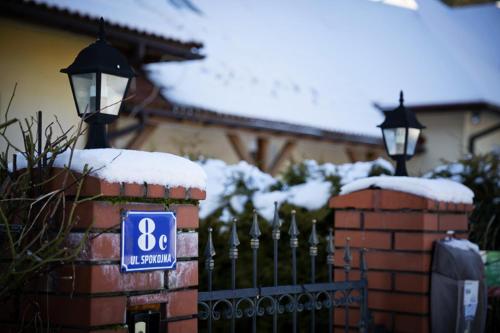 a blue sign on a fence with snow on it at Willa i domki Victoria in Wisła