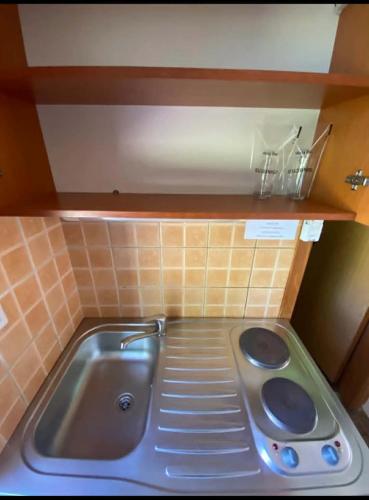 a small kitchen with a sink in a kitchen at Camp Rooms in Jajce
