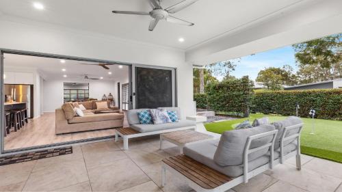 a living room with a patio with a couch and chairs at Alkira at The Vintage in Pokolbin