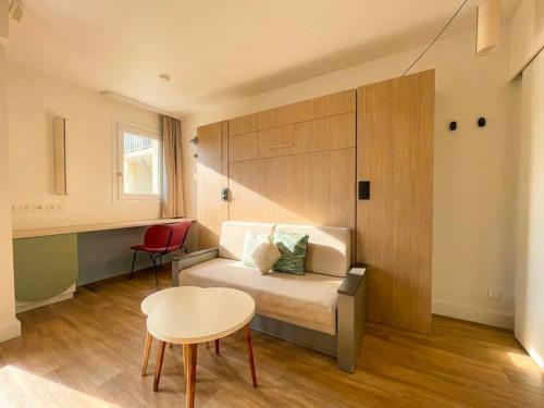 a bedroom with a bed and a table and a desk at Residence Pierre & Vacances Les Embruns in Deauville