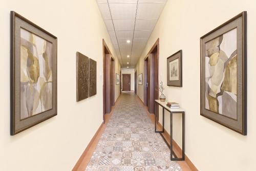 a corridor of a hallway with paintings on the walls at FabHotel Shivalika in Jaipur