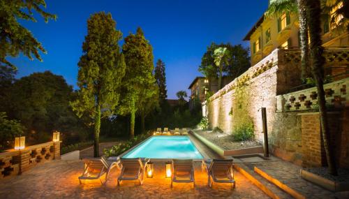 an outdoor swimming pool with chairs and a building at Apartments Atlanta in Lovran