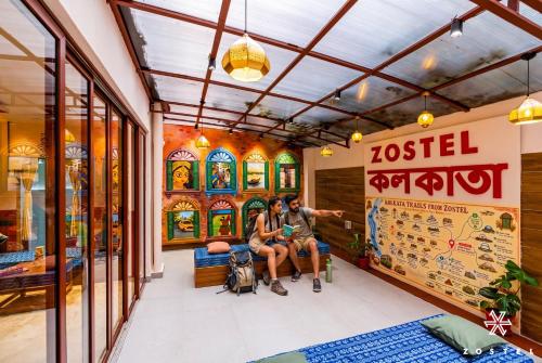 a group of three people sitting in a store lobby at Zostel Kolkata in Kolkata
