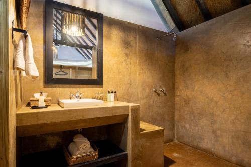 a bathroom with a sink and a mirror at Masuwe Lodge in Victoria Falls
