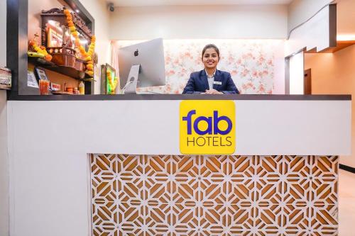a woman standing behind a counter with a ibid hotels sign at FabHotel SK Galaxy in Thane