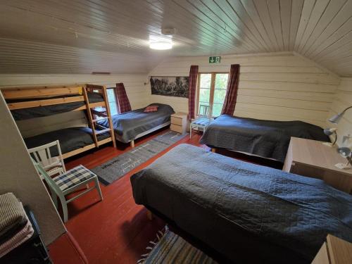 a room with two beds and two bunk beds at Åreholtet log cabin, Norway in Kleppo