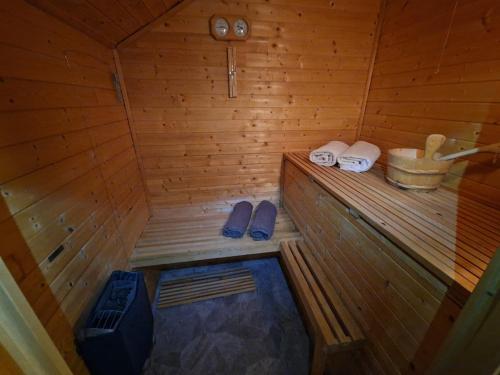 a sauna with two slippers and a bucket at Åreholtet log cabin, Norway in Kleppo