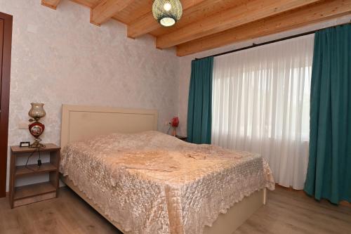 a bedroom with a bed and a large window at Hilltop Jikha in Jikhaskari