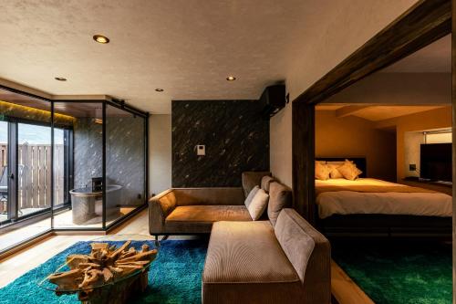 a bedroom with a bed and a couch and a bed at OOkami Villa in Omachi