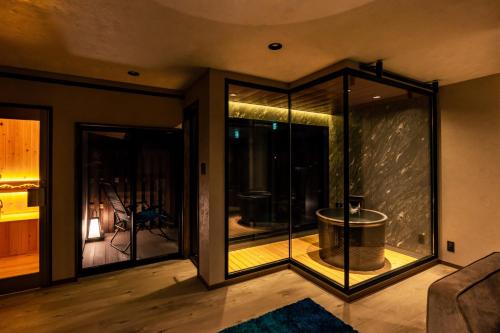 a room with a large glass window with a tub at OOkami Villa in Omachi