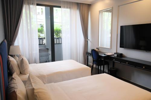 a hotel room with two beds and a flat screen tv at Indigen Boutique Hotel Cao Bang in Cao Bằng