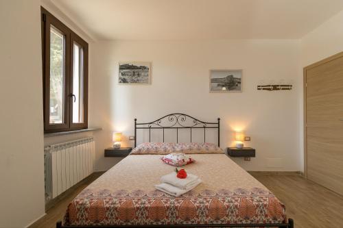 a bedroom with a bed with towels and two lamps at Villa Adelmo appartamento privato in Pomarance