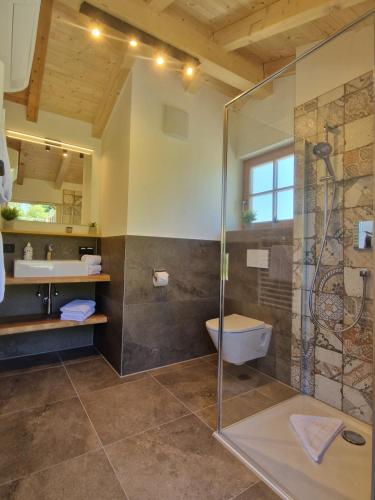 a bathroom with a shower and a toilet and a sink at Ferienhof AllgäuMax in Füssen