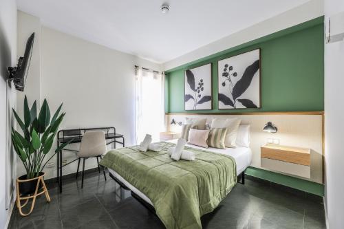 a bedroom with a bed with a green wall at UP Hotel Velilla in Velilla de San Antonio
