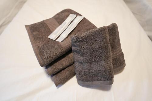 a couple of towels sitting on a bed at The CATAN 宮津 in Yura