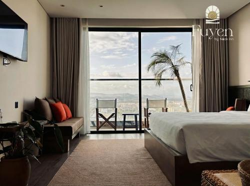 a hotel room with a bed and a large window at Nook Inn - Apec Phu Yen in Tuy Hoa