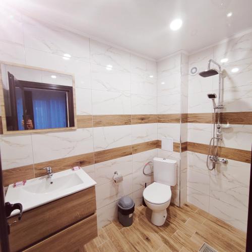 a bathroom with a toilet and a sink and a shower at Къща за гости КрисиЯна in Zlatograd
