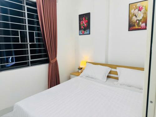 a bedroom with a white bed and a window at Harmony Apartment in Hanoi
