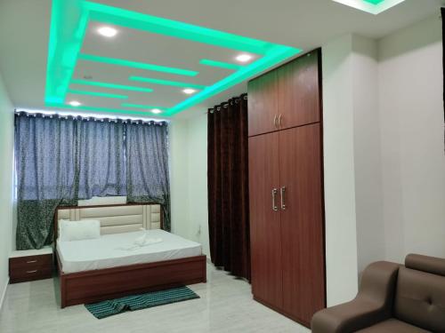 a bedroom with a bed and a blue ceiling at Hotel Raj in Letekujān