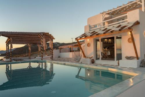 a villa with a swimming pool and a house at Silia Dream View in Houlakia