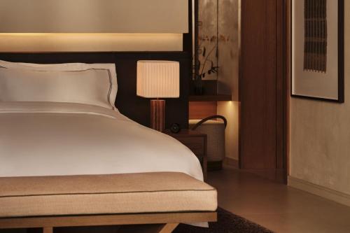 a bedroom with a white bed and a lamp at Rosewood AMAALA in Amala