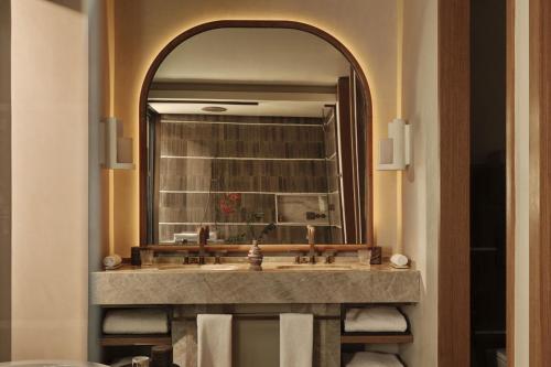 a bathroom with a sink and a large mirror at Rosewood AMAALA in Amala