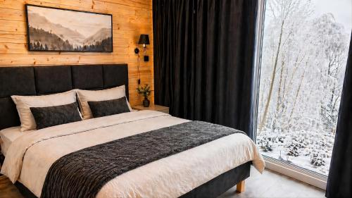 a bedroom with a bed and a large window at Domek SPA z sauną i jacuzzi - Level780 in Koszarawa