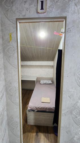 a small room with a small bed in a wall at JONIKA Sleep & Go Inn in Aktepa-Chigatay