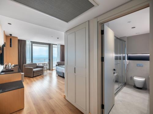 a room with a bathroom with a view of the ocean at Korumar Hotel Deluxe in Kuşadası