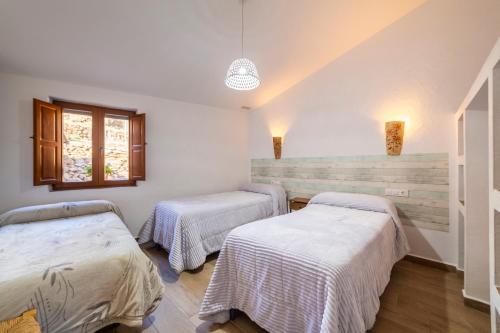 a room with two beds and a window at Yerbaluisa in Laroya