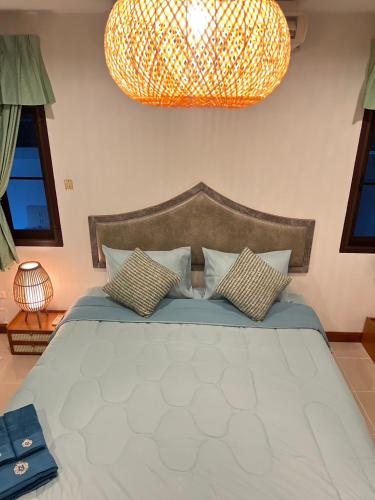 a bedroom with a large bed and a large light fixture at Bungalow Apartment Kamala in Phuket