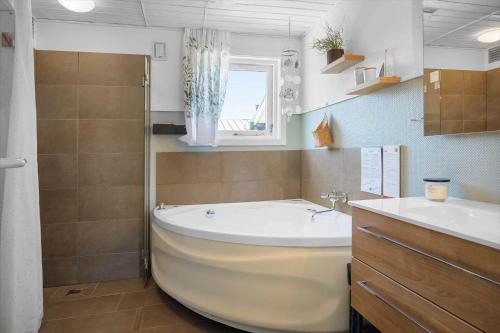 a bathroom with a large tub and a sink at 136-Snedsted-Lykkens-Hab-23 in Snedsted