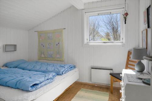 a bedroom with a bed with blue sheets and a window at 136-Snedsted-Lykkens-Hab-23 in Snedsted