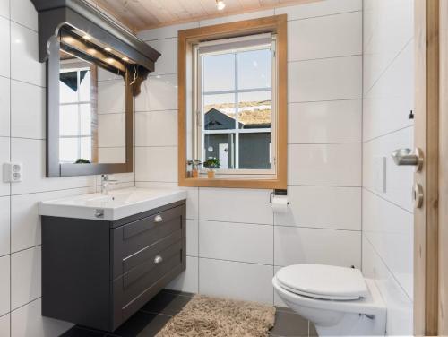 a bathroom with a toilet and a sink and a window at Ski cabin in Hafjell in Øyer