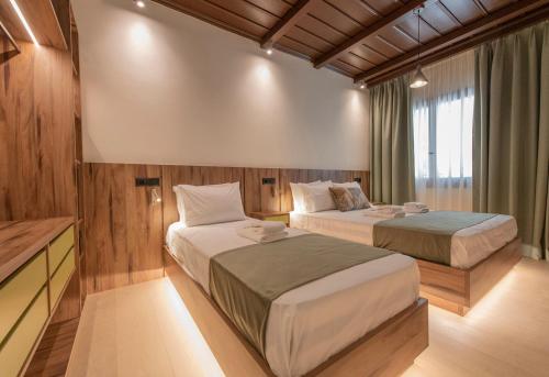 two beds in a room with wooden walls at Balcon Makrinitsa in Makrinitsa