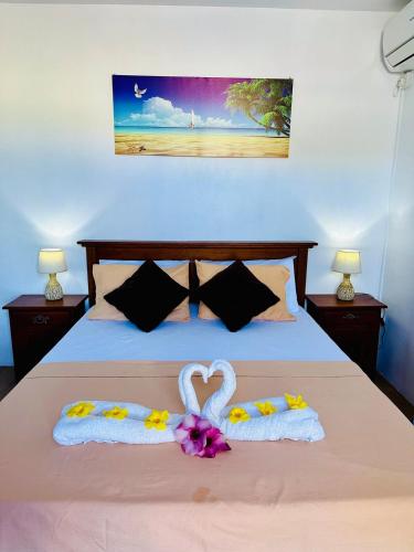 a bedroom with a bed with two towels and a heart shapedvisorvisor at sunsetvilla studio in Saint-Martin