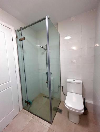 a bathroom with a toilet and a glass shower at Villa Peony Koroni in Koroni