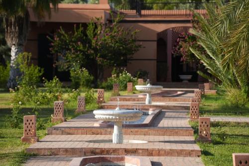 a group of three fountains in a park at Domaine 3 Riads in Marrakesh