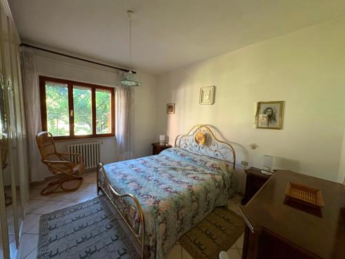 a bedroom with a bed and a chair and a window at Da Gabriele è vacanza in Gubbio