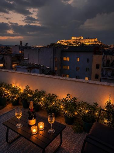 a balcony with a table with wine glasses and lights at KK Athens Fine Stay -Neos Kosmos-Modern Apartments Opposite Metro with Rooftop Lounge & Acropolis Views in Athens
