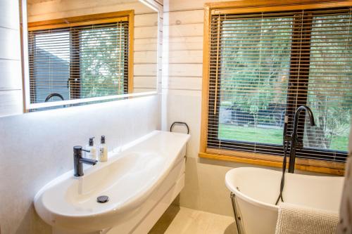 a bathroom with a sink and a tub and a window at The Larch House in Chester