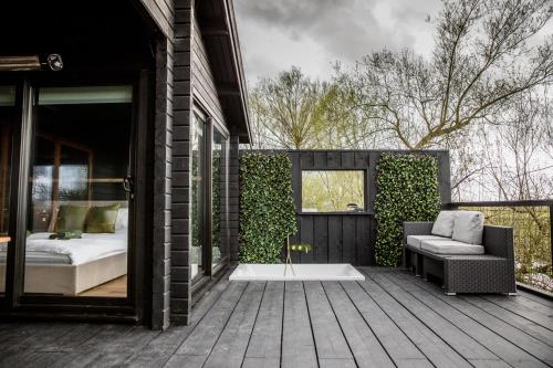 a bedroom on a deck with a bed and a couch at The Larch House in Chester