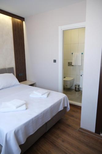 a bedroom with a bed and a bathroom with a toilet at Mudanya Yıldız Otel in Mudanya