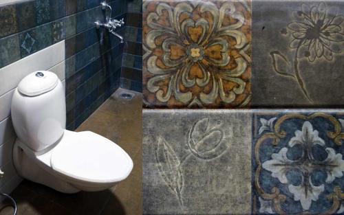 bagno con servizi igienici e mosaici alle pareti di Nirvana Inn a Mahabaleshwar