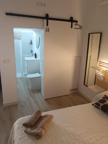 a bedroom with a bed with a mirror and a sink at SG Estudios Sanlúcar in Sanlúcar de Barrameda