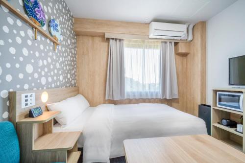 a hotel room with a bed and a tv at Tabino Hotel EXpress Narita in Narita