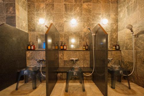 a bathroom with four urinals and a shower at Tabino Hotel EXpress Narita in Narita